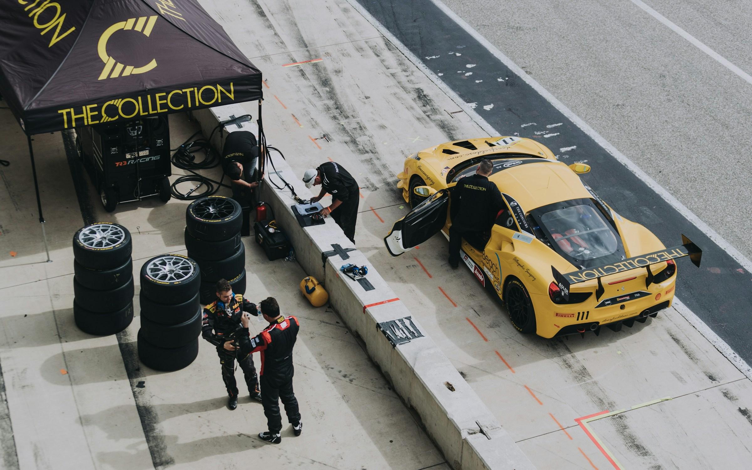 Ferrari GT3 en boxes, con el equipo y las gomas listas para salir a pista